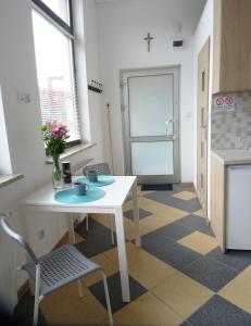 a kitchen with a table and a white table and a chair at Nowy Apartament Słoneczny in Augustów