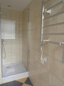 a shower with a glass door in a bathroom at Nowy Apartament Słoneczny in Augustów