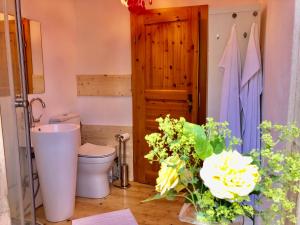 a bathroom with a toilet and flowers on the floor at Im Herzen von Ohlstadt und am Fusse des Heimgartens in Ohlstadt +15 photos