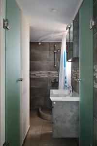 a bathroom with a sink and a shower at Panorama Hotel in Agia Marina Aegina