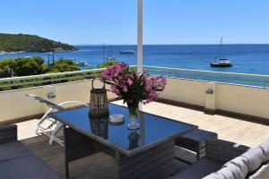 a table on a balcony with a view of the ocean at Panorama Hotel in Agia Marina Aegina
