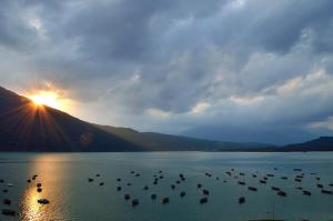 um grupo de barcos na água ao pôr do sol em Locanda San Lorenzo em Puos dʼAlpago