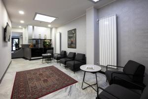 una sala d'attesa con sedie nere e un tavolo di Hotel Esperia a Rho