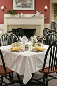 Inn at Jackson في جاكسون: طاولة طعام مع طاولة بيضاء من قماش وكراسي