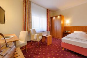a hotel room with a bed and a desk at Mercure Hotel Luebeck City Center in Lübeck