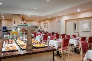 a restaurant with tables and chairs and food on a counter at Sunotel Junior in Barcelona