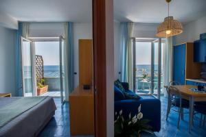 a bedroom with a bed and a room with a view of the ocean at Residence Panoramic in Maiori
