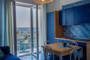a kitchen with blue cabinets and a table with chairs at Residence Panoramic in Maiori