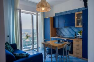a kitchen with blue cabinets and a table with chairs at Residence Panoramic in Maiori
