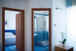a bathroom with a shower and a bed and a mirror at Residence Panoramic in Maiori