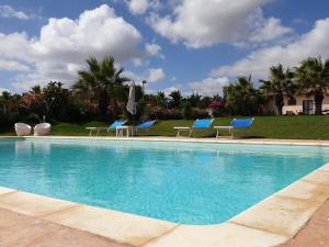 a swimming pool with chairs and umbrellas at Agliadò in Platamona