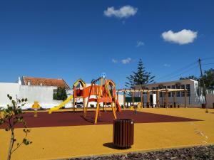 a playground with a slide and a trash can at Villa Figueira in Portimão