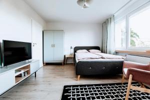 a bedroom with a bed and a flat screen tv at Gdynia Square Apartment in Gdynia