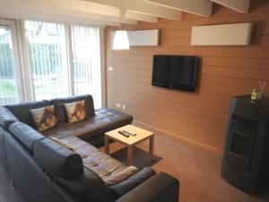 un soggiorno con divano e TV a schermo piatto di maison 3 chambres à 200 m de la plage des Barrages de l Eau d Heure a Froidchapelle
