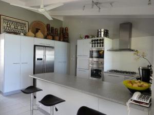 a kitchen with a counter with stools in it at Sunset Quay in Rarotonga