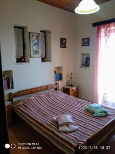 1 dormitorio con 1 cama con 2 almohadas en Balcony on Trichonida Lake en Kríon Nerón