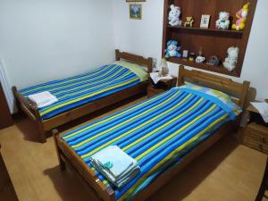 een slaapkamer met 2 aparte bedden en knuffeldieren bij Balcony on Trichonida Lake in Kríon Nerón