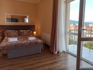 um quarto com uma cama e uma grande janela em Panoramic View Lux Apartment em Mukacheve