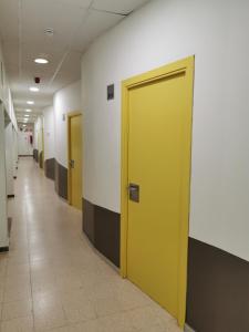 a hallway with two yellow doors in a building at Alberg Coma-ruga Xanascat in Comarruga