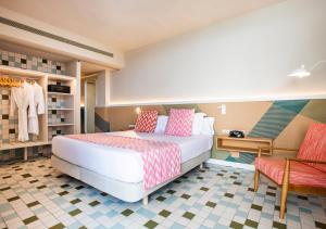 a bedroom with a bed and a table and a bench at Inturotel Cala Esmeralda Beach Hotel & Spa - Adults Only in Cala d´Or +79 photos