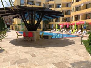 サニービーチにあるComplex Sands Holiday Apartmentsのパティオ(テーブル、椅子付)、プールが備わります。