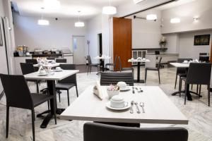 a dining room with tables and chairs and a kitchen at Hotel Esperia in Rho