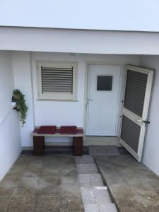 um alpendre com um banco à frente de uma porta em Casa-Lisa seminterrato em Miggiano