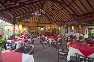 a restaurant with red and white tables and chairs at Natah Bale Villas in Sanur