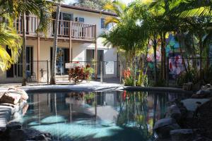 a swimming pool in front of a building with a house at Pippies Beachhouse Backpackers in Rainbow Beach