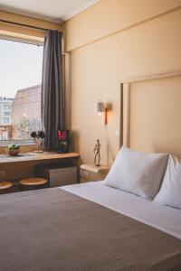una stanza d'albergo con un letto e una finestra di Acropolis View - Living Stone Sapphire Apartment ad Atene
