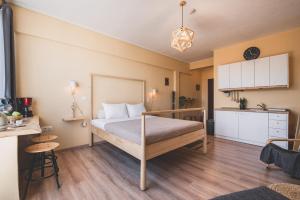 małą sypialnię z łóżkiem i kuchnią w obiekcie Acropolis View - Living Stone Sapphire Apartment w Atenach