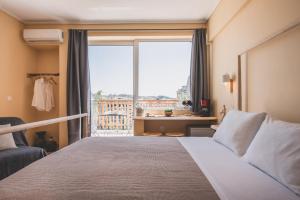 una camera da letto con un letto e una grande finestra di Acropolis View - Living Stone Sapphire Apartment ad Atene
