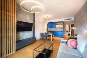 a living room with a couch and a dining room at Apartament DEO PLAZA in Gdańsk