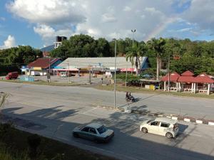 dois carros estacionados numa rua numa cidade em Arjuwani Homestay Gua Musang em Gua Musang