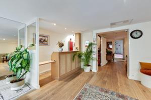 a hallway with potted plants and a clock on a wall at Louisa Hotel Paris in Paris