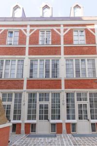 a large brick building with white doors and windows at Lofts Philippe-Auguste in Paris