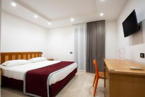 a bedroom with a bed and a desk and a television at Villa La Ventana in Sant'Agnello
