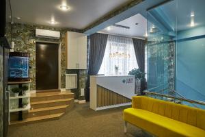 een lobby met een gele bank en een aquarium bij JULY Hotel in Stavropol