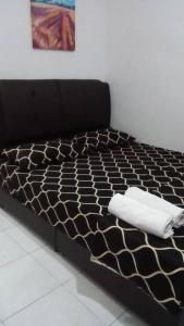 a black bed with two white towels on it at Wany Homestay in Sungai Petani