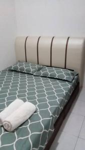 a bed with a blanket and two pillows on it at Wany Homestay in Sungai Petani