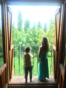 a boy and a girl looking out of a window at Apartamentos Chuandervera in Laspaúles