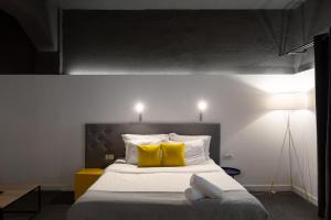 sypialnia z dużym łóżkiem z żółtymi poduszkami w obiekcie Hotel Bohemian Garni - Skadarlija w Belgradzie