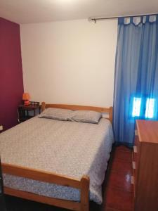- une chambre avec un lit et un rideau bleu dans l'établissement Casa Vilar, à Gerês