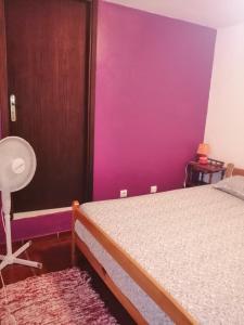- une chambre avec un lit et un mur violet dans l'établissement Casa Vilar, à Gerês