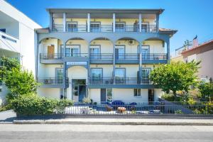 un edificio de apartamentos con balcones azules y árboles en Versa Studios, en Limenas