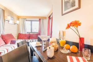 a living room with a table and a couch at Résidence Saskia Falaise - Avoriaz in Morzine