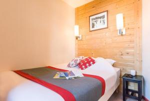 - une chambre avec un lit et un mur en bois dans l'établissement Résidence Saskia Falaise - Avoriaz, à Morzine