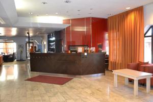a lobby with a counter and a table at Hotel Oscar in Varkaus
