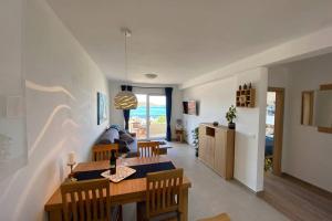 a dining room and living room with a table and chairs at Apartment Sandra (2+2) with a breathtaking view 2 in Vis