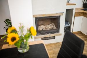 un jarrón de flores sobre una mesa con chimenea en Malinowy Chruśniak Apartamenty, en Hoczew